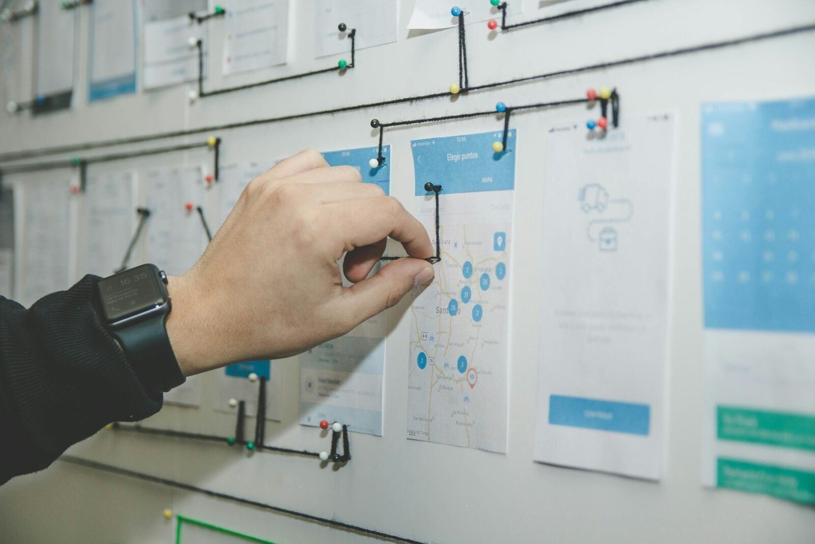 Person mapping out a process with paper notes on a board